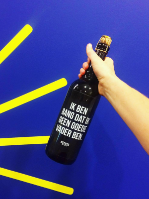 A picture of a 1L beer bottle labeled with a masculine insecurity ('Ik ben bang dat ik geen goede vader ben.')